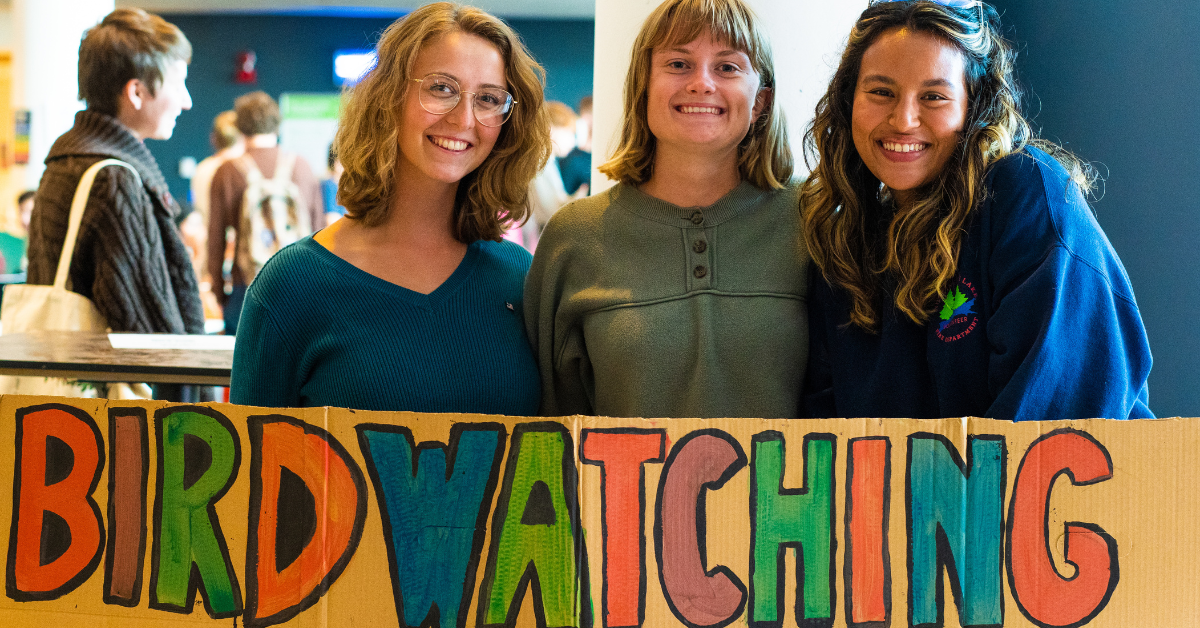 Students playing volleyball at the beach.
