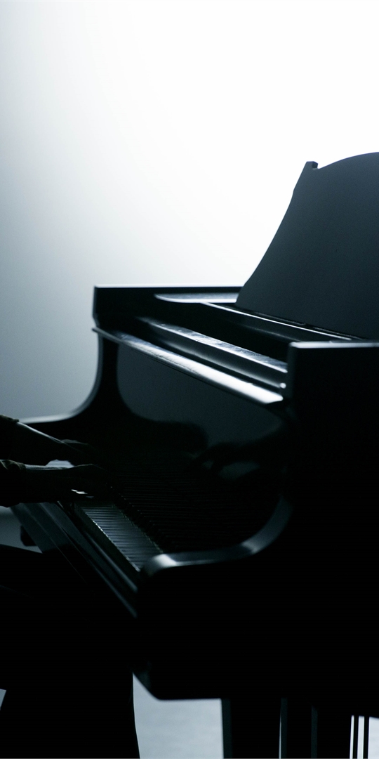 Silhouette of a person playing piano.