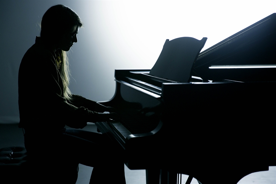 Silhouette of a person playing piano.