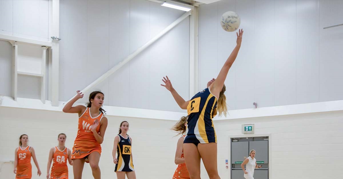 An action shot of people playing netball