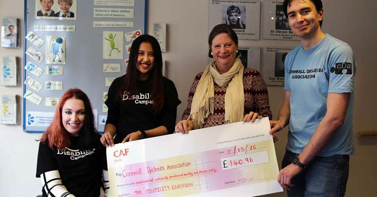 A group of students holding a large fundraising cheque