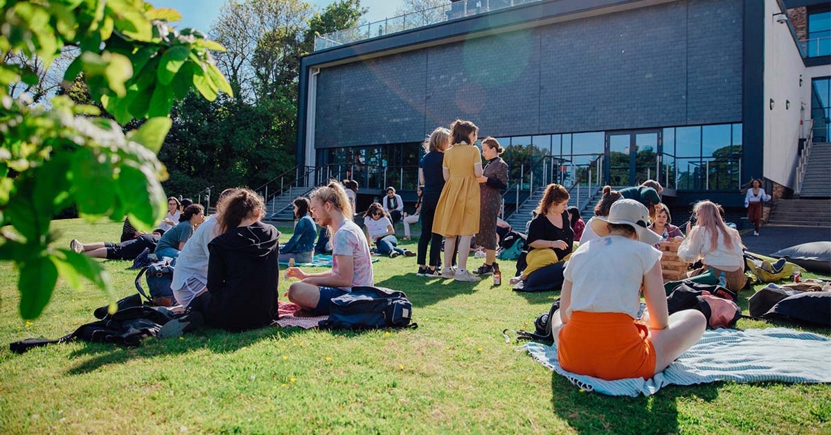 Students all sat on the grass outside one of the FXU buildings