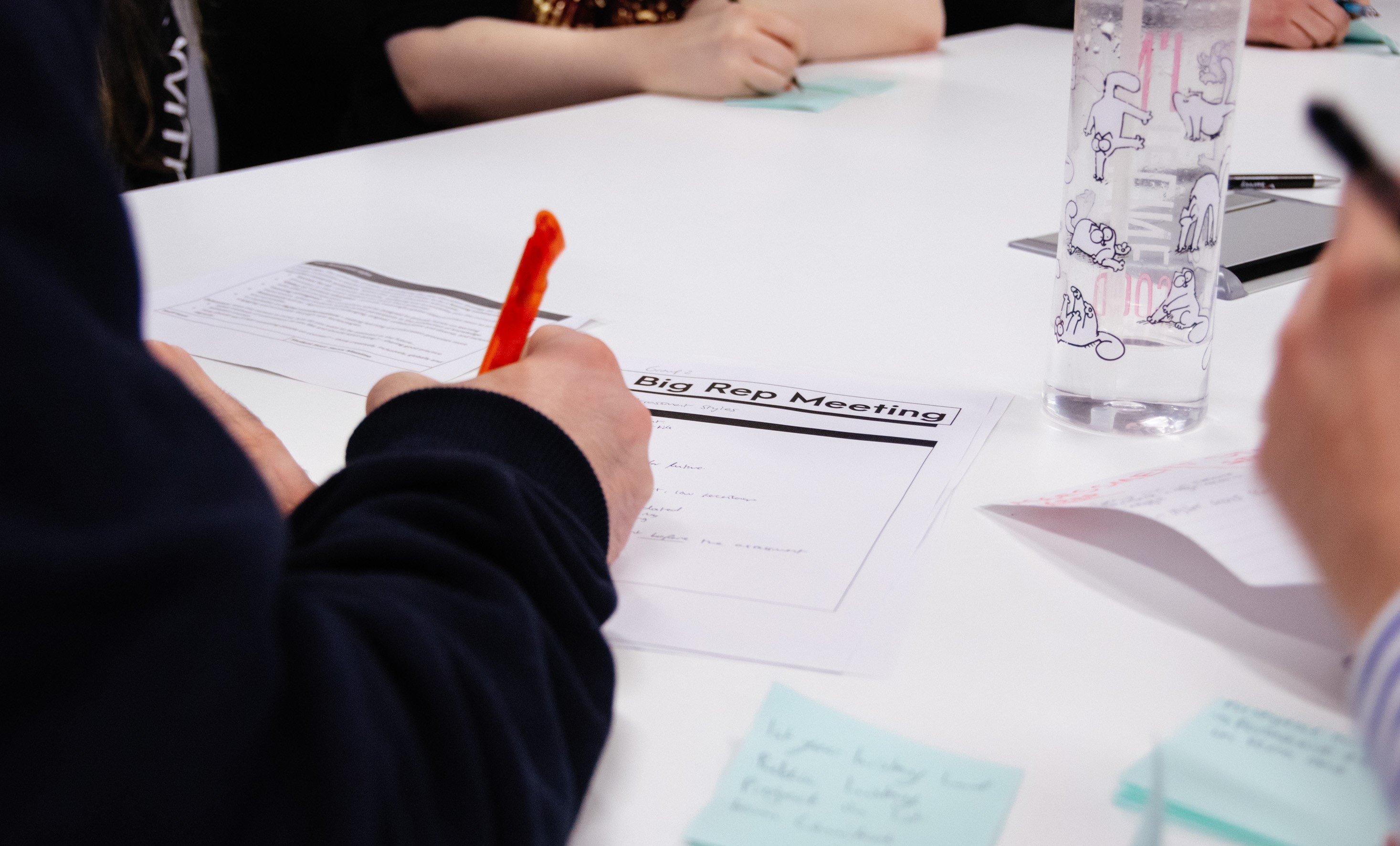 A hand writing on a Big Rep Meeting handout.