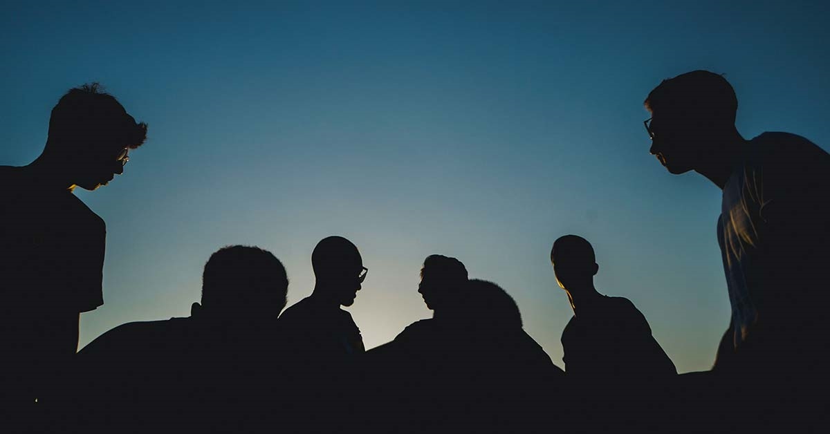A silhouette of a group of people at sunset