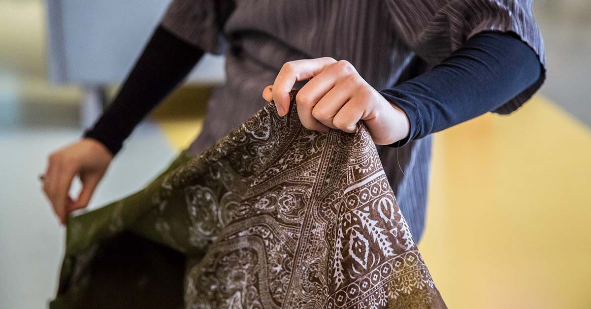 A student holding some fabric